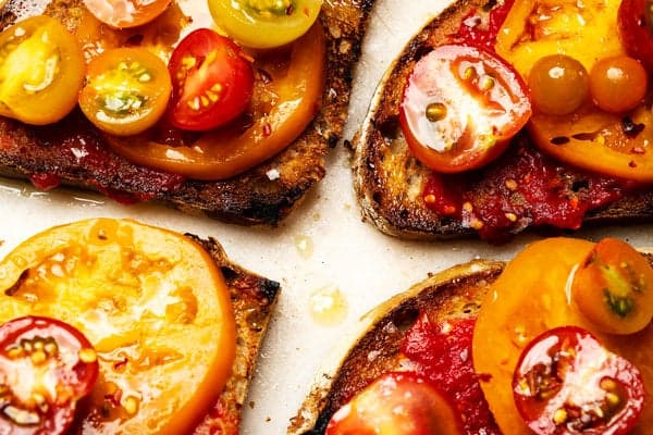 An overhead shot of toast with tomatoes on top.