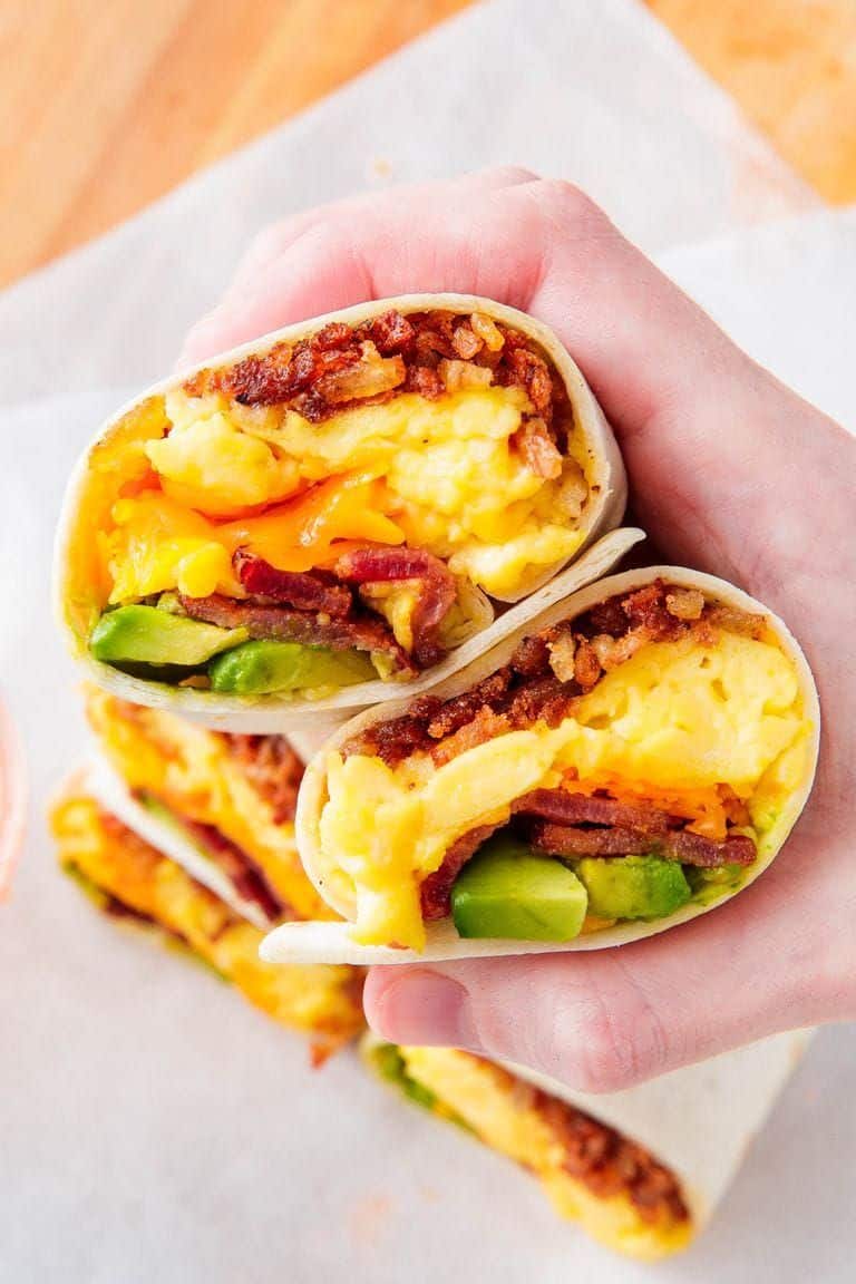 A front shot of a breakfast burrito cut in half.