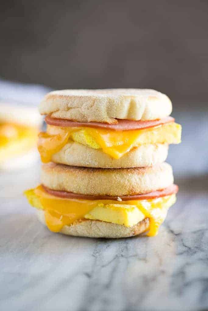 A side shot of a stack of breakfast sandwiches.