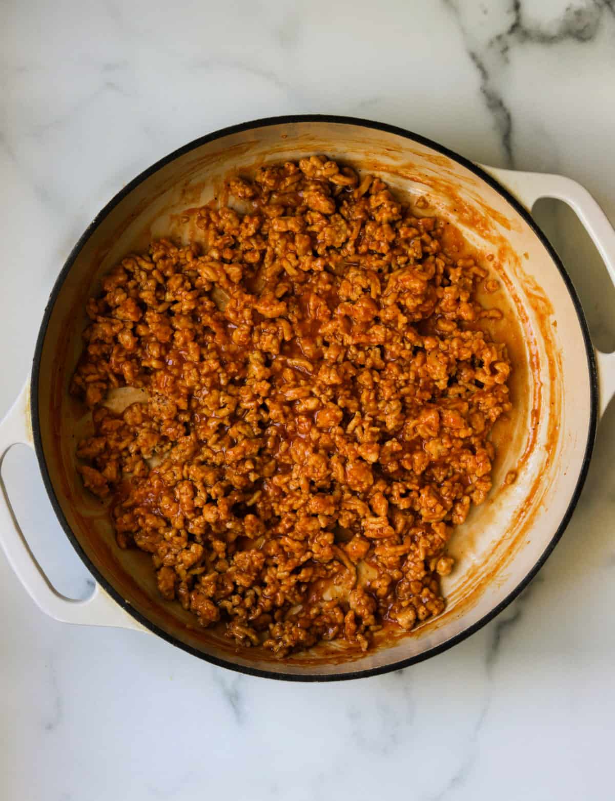 A skillet filled with ground chicken sloppy joe meat.