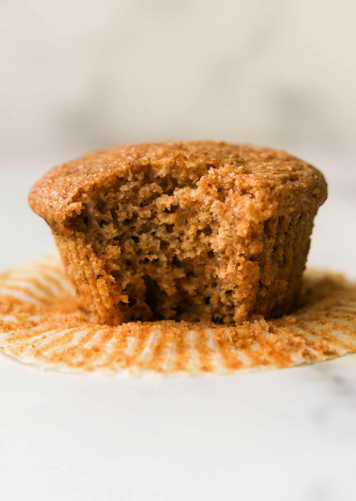 A front shot of a bran muffin with a bite taken out of it.