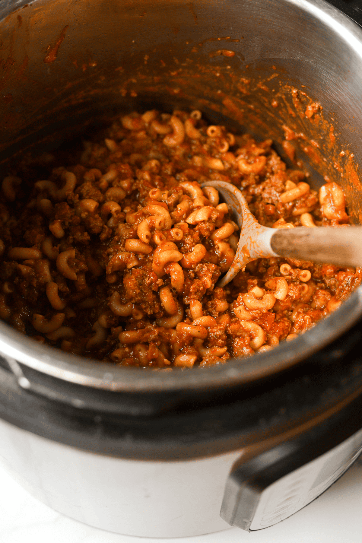 A side shot of an Instant Pot full of cheesy goulash.