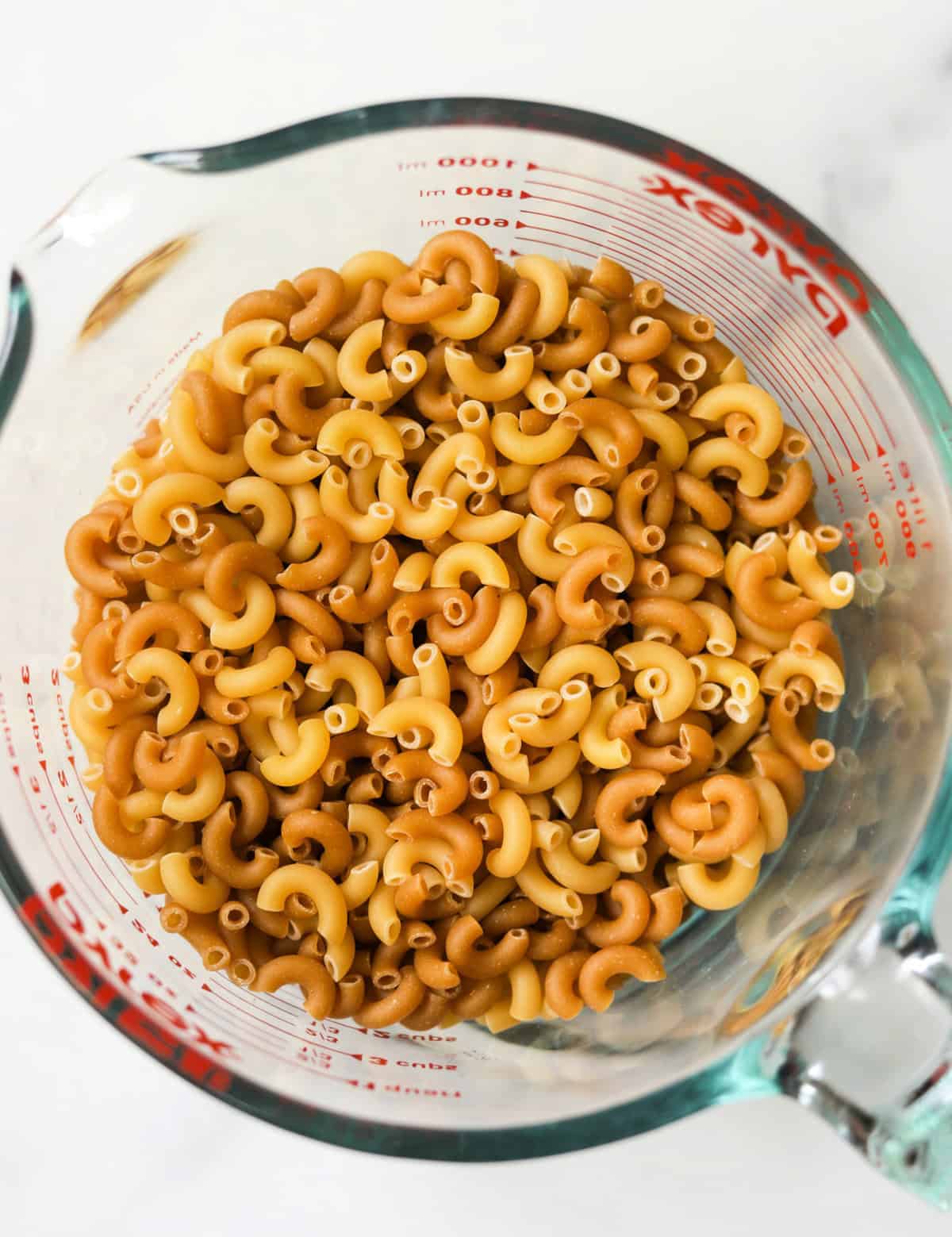 A close up overhead shot of a bowl of elbow macaroni.