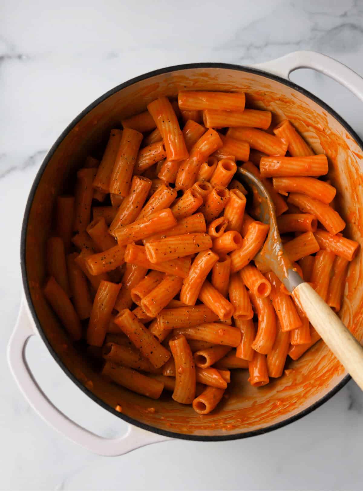 An overhead shot of a pot of spicy gochujang pasta with a spoon in the pot.