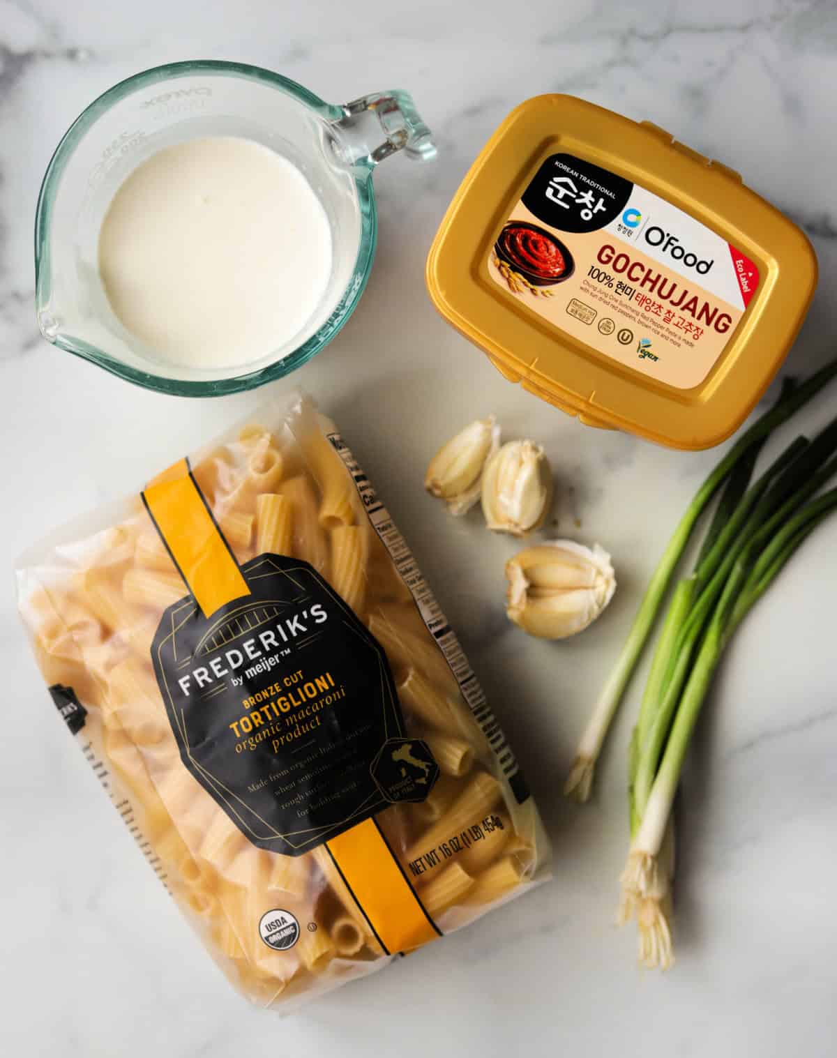 An overhead shot of aingredients for creamy gochujang pasta on a marble countertop.