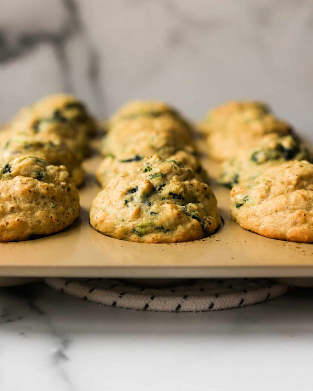 A front shot of spinach feta muffins in a tin.