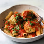 Air fryer turkey zucchini meatballs in a bowl with rigatoni and marinara.